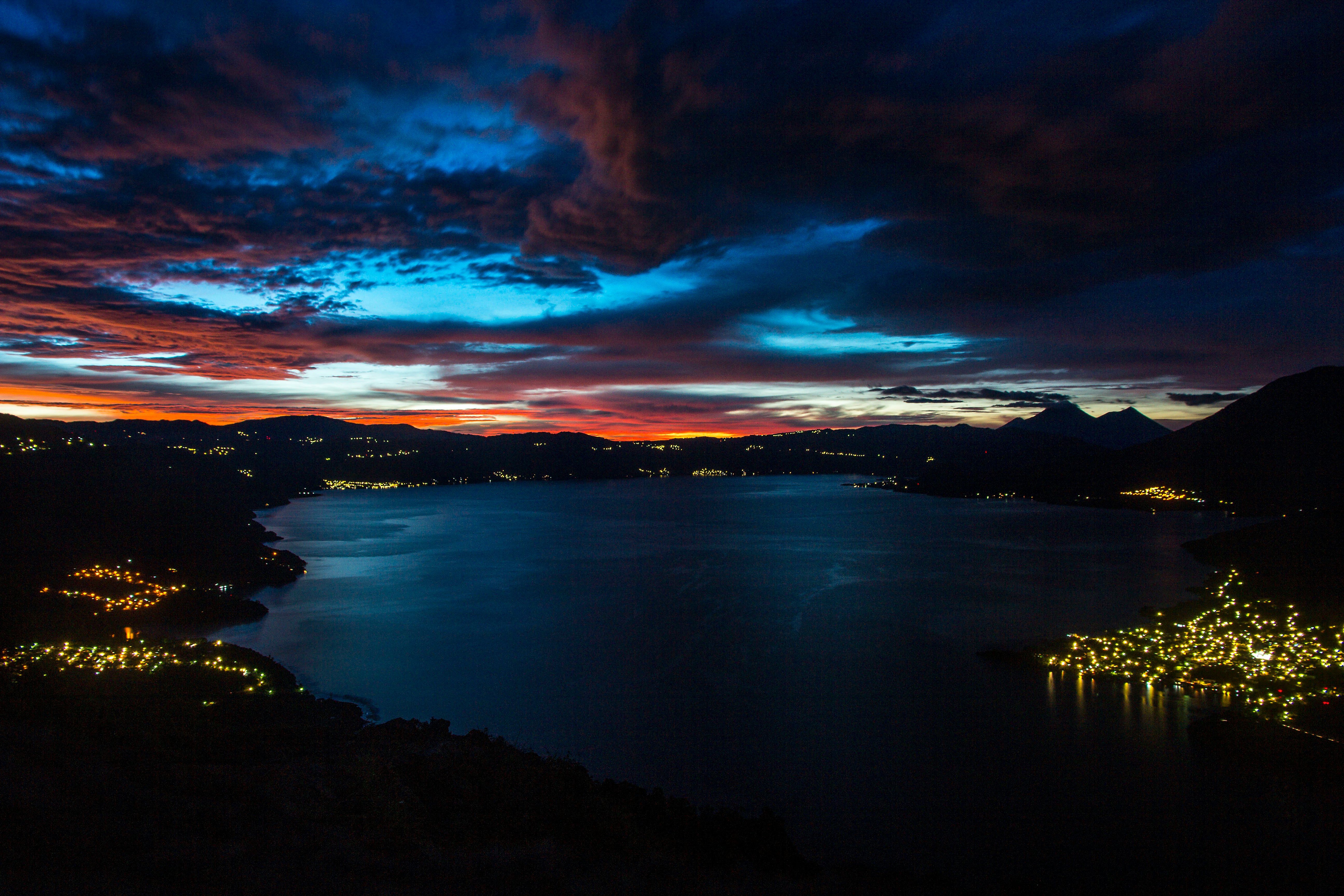 calm body of water near mountain during night time